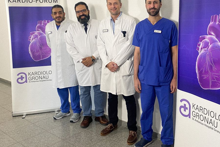 Die Ärzte der kardiologischen Klinik stehen von links nach rechts an einer Wand, eingerahmt von zwei Aufstellern zum Kardio-Forum: 