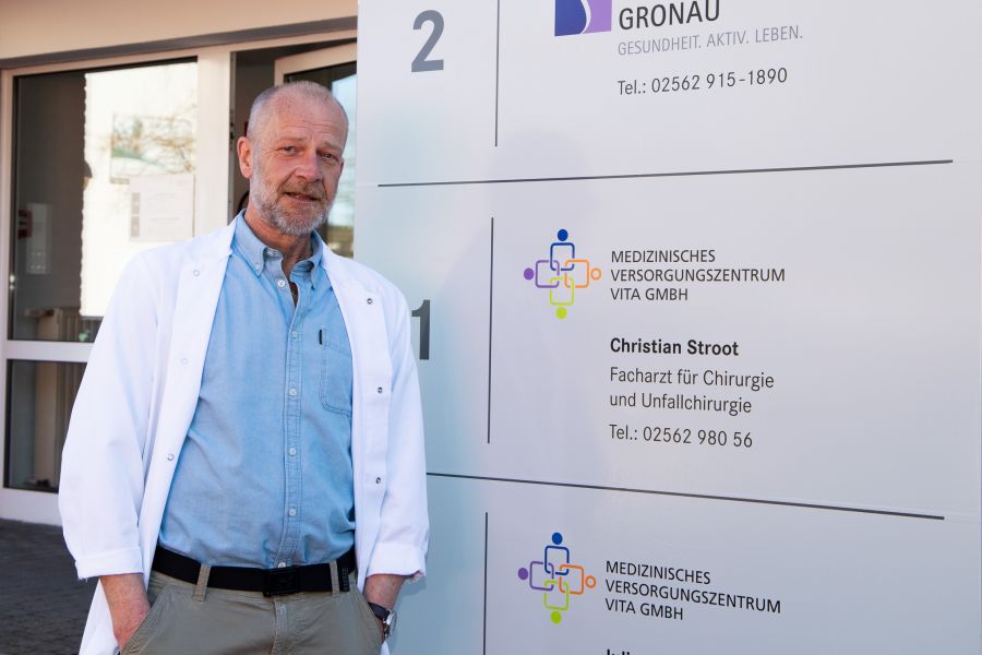 Christian Stroot steht vor dem Eingangsschild der MVZ-Praxis. 